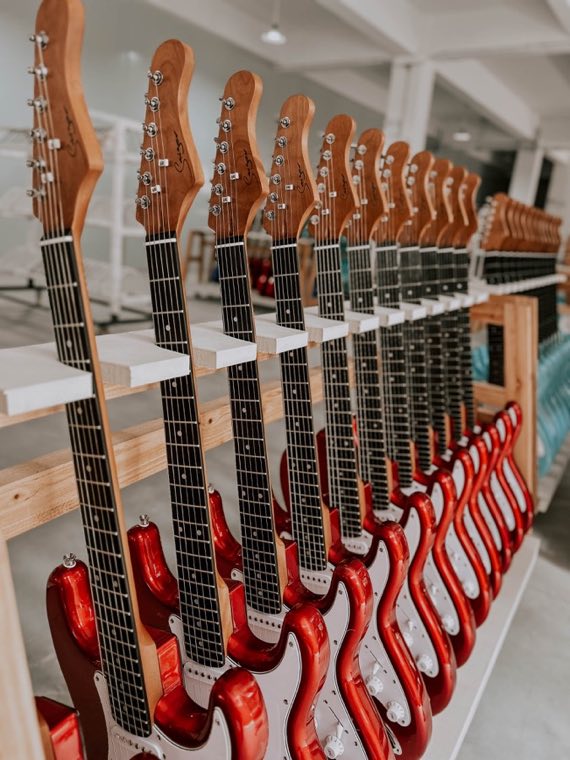 Rows of assembled electric guitars arranged for organised inspection